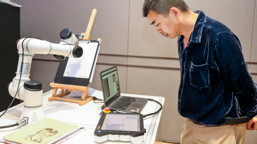 嘉賓體驗(yàn)遨博AI繪畫機(jī)器人。主辦方供圖